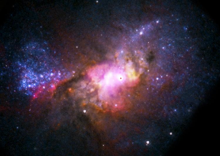 На снимке - карликовая галактика Henize 2-10. Предполагаемое местоположение черной дыры отмечено крестиком