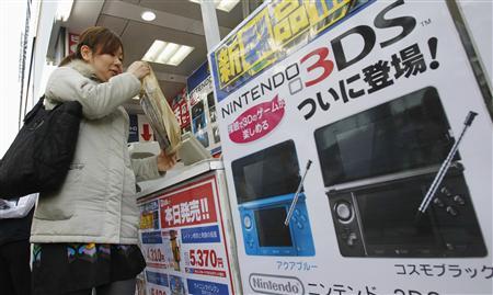 Женщина приобретает Nintendo 3DS в магазине электроники в день запуска